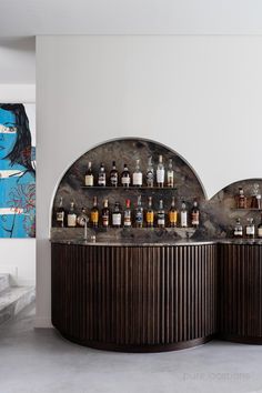 the bar has many bottles on it and is next to a painting that looks like a woman's face