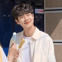 a man and woman standing next to each other holding an ice cream cone in their hands