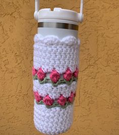 a crocheted coffee cup holder hanging from a hook