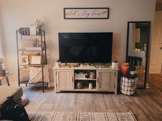 a living room filled with furniture and a flat screen tv on top of a wooden entertainment center