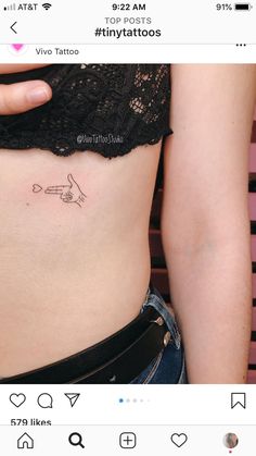 a woman's stomach with a small tattoo on the left side of her belly