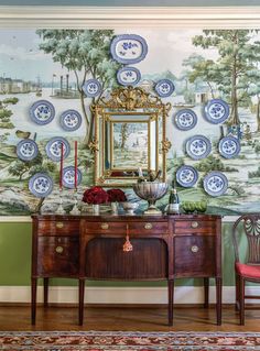 a table with two chairs and a mirror on it in front of a wall mural