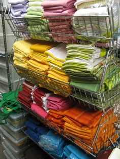 a metal rack filled with lots of folded shirts