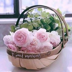 a basket filled with pink roses sitting on top of a table