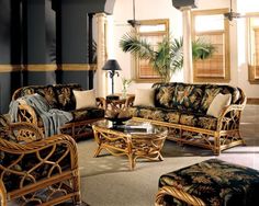 a living room with wicker furniture and palm trees on the wall in it's corner