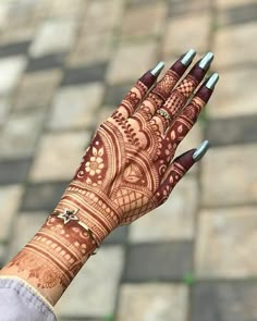 a woman's hand with henna tattoos on it