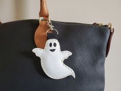 a handbag with a ghost keychain hanging from it