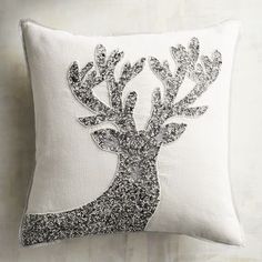 a white pillow with silver sequins and a tree on the front is shown