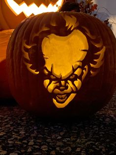 two carved pumpkins sitting on the ground next to each other with faces carved into them