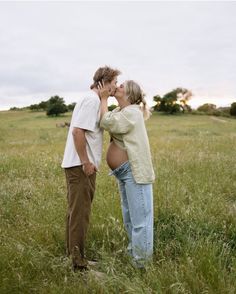 a man and woman kissing in a field