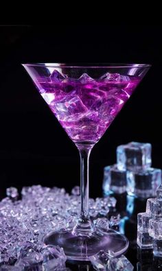 a purple drink with ice cubes in the background