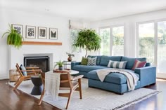 a living room filled with furniture and a fire place in front of a window on top of a hard wood floor