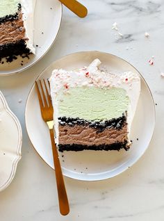 two plates with slices of cake on them, one has white frosting and the other has green icing