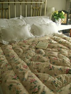 a bed with white pillows and floral comforter