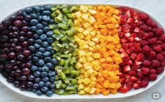 a rainbow fruit platter with berries, kiwis, and raspberries