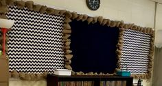 a room with bookshelves and curtains on the wall above them is decorated in black and white checkered fabric