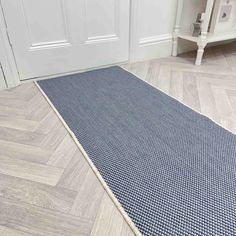 a blue rug on the floor in front of a white door