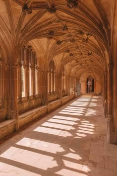 the sun is shining in an old building with stone arches and columns on both sides