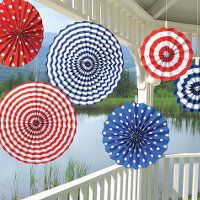 several red, white and blue umbrellas are hanging from a porch railing over water