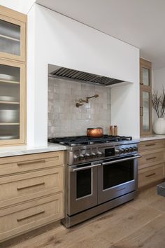 a stove top oven sitting inside of a kitchen next to wooden cabinets and counter tops