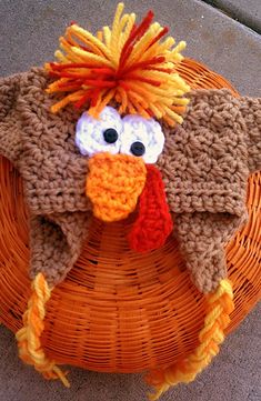 a knitted turkey hat sitting on top of a wicker basket