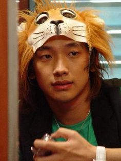 a young man wearing a lion mask and looking at his cell phone in front of him