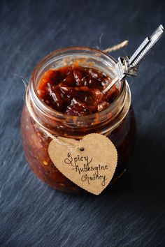 a jar filled with jam sitting on top of a black table next to a tag