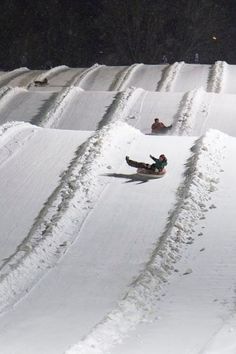 two people riding down a snow covered slope