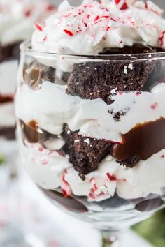 a dessert in a glass with white frosting and candy canes on top is ready to be eaten