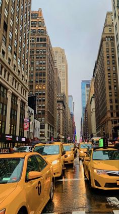 a city street filled with lots of traffic and tall buildings on either side of it