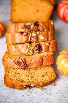 slices of pumpkin bread with nuts and cranberries next to them on a table