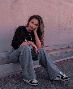 a woman sitting on a bench with her hand under her chin