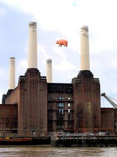 a large brick building with two pigs flying over it