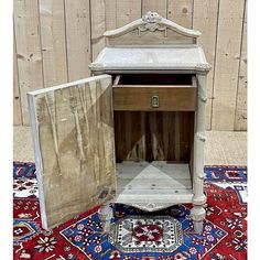 an old wooden cabinet sitting on top of a rug