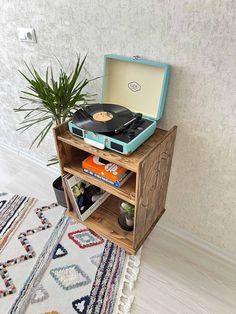 an open suitcase sitting on top of a wooden shelf next to a potted plant