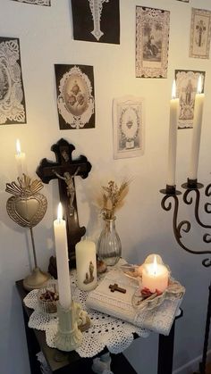 a table with candles and pictures on the wall