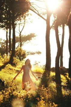 a woman walking through the woods with her hand in her pocket and a bible verse above her