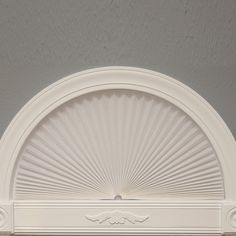 a white fireplace mantle with a sunburst design on it