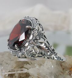 "Red Garnet Ring (Choose Garnet CZ or a Natural Red Garnet Gemstone) Beauty Design#229 MADE TO ORDER Ring Description This is a brand new stunning Art Nouveau/Victorian reproduction sterling silver filigree ring. The flawless oval-cut high-quality 5ct Red Garnet gemstone is 12mm by 10mm (just shy of 3/8\" inch) in dimension. (Choose between a Red Garnet CZ or a Natural 5ct Natural Garnet (VVS)). The ring is 5/8th of an inch (16.5mm) NS (long) on the finger. The ring and gem sit 7mm off the finge Vampire Diaries Jewelry, Gothic Engagement Ring, Sky Blue Topaz Ring, Red Garnet Ring, Gem Art, Gemstone Art, Garnet Gem, Order Design, Gems Art