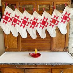 christmas stockings hanging from a line on a kitchen counter with a candle in the middle