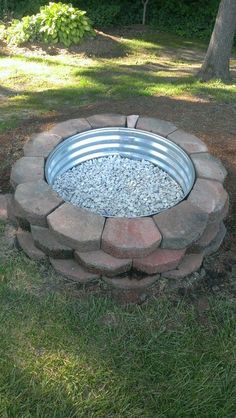 a fire pit made out of bricks in the grass