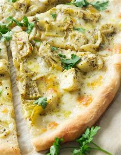 a pizza with cheese and herbs on it