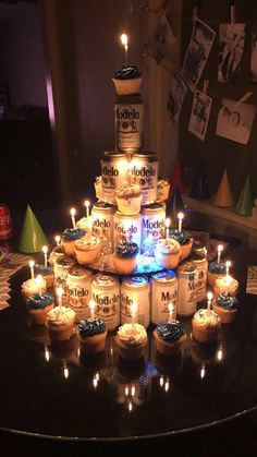 cupcakes with candles are arranged in the shape of a pyramid on a table