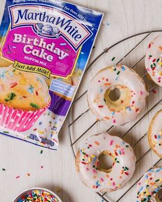 birthday cake doughnuts with frosting and sprinkles on a cooling rack