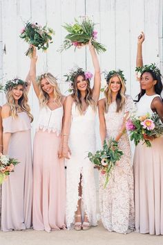 a group of women standing next to each other holding flowers in their hands and wearing flower crowns