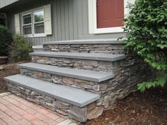 stone steps lead up to the front door of a house