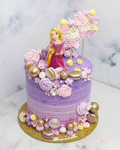 there is a purple cake decorated with flowers and a princess figurine on top