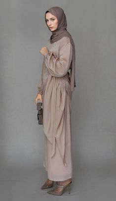 The Lulule Maxi Abaya Dress by Annah Hariri is the epitome of style and comfort. This light beige dress is crafted with a blend of satin and polyester, providing you with a luxurious and comfortable experience. The elasticated sleeves and tie waist piece offer a customizable fit, allowing you to adjust the dress to your body shape. The detached apron adds a touch of elegance to the design, making it a versatile piece that can be styled in various ways.Whether you choose to wear it front-knotted Light Beige Dress, Annah Hariri, Modest Chic, Modest Activewear, Luxurious Dress, Full Coverage Swimsuit, Luxurious Dresses, Beige Dress, Abaya Dress