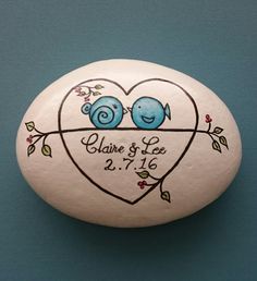 a painted rock with two birds on it