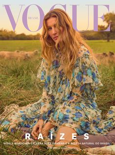 a woman sitting in the grass on top of a magazine cover